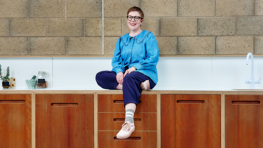 Anna Moynihan sitting on a kitchen work front 