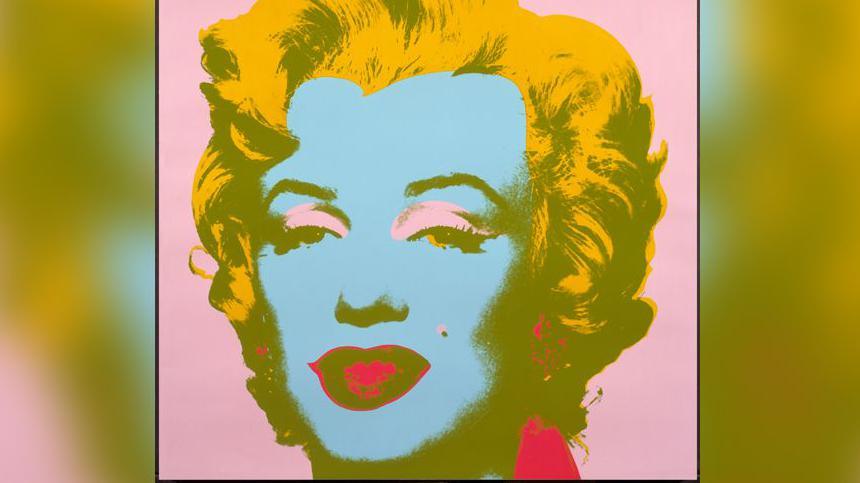 A picture of Marilyn Monroe by Andy Warhol, her face is created on a pink background, her hair is yellow, her face blue with pink eye shadow and red lips