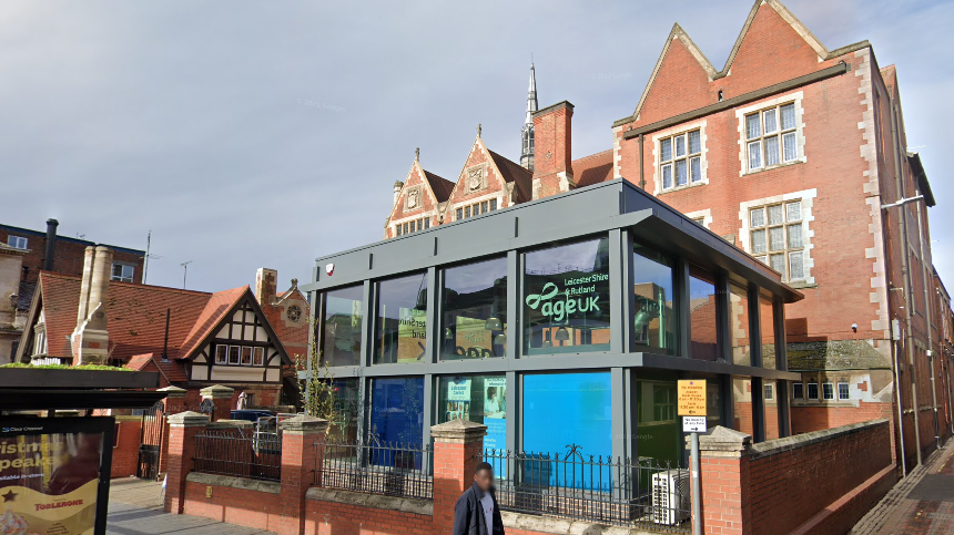 The exterior of Age UK's premises in Leicester. There is a modern grey-framed structure in front of the main red-brick building.