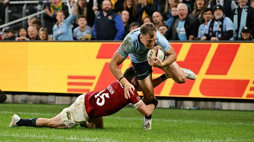 Darby Lancaster breaks free from Hugo Keenan's attempted tackle to score for the Waratahs