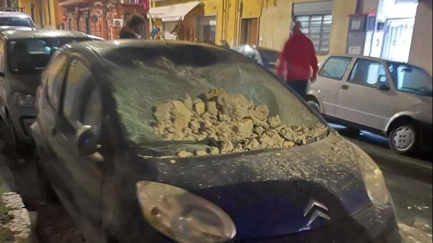 Rubble on a car in a narrow street in Pozzuoli near Naples