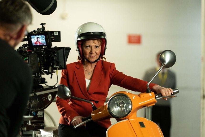 Bonnie Langford wearing a helmit and sitting on a scooter