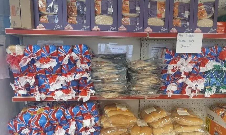 Rows of bread and bread rolls on two of three shelves. The top shelf includes other products. 