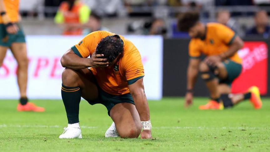 Australia players look distraught after their 2023 World Cup defeat by Wales