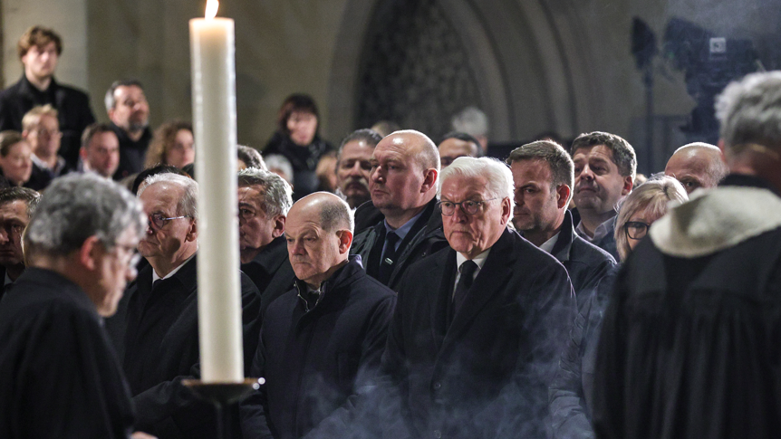 Clergymen pass by German Chancellor Olaf Scholz (SPD) (C-L) and German President, Frank-Walter Steinmeier (C-R) during a prayer ceremony at the Magdeburg Dom church