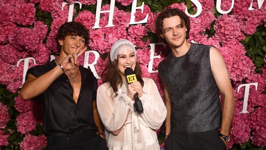 Gavin Casalegno, Lola Tung and Christopher Briney pose on a red carpet promoting The Summer I Turned Pretty