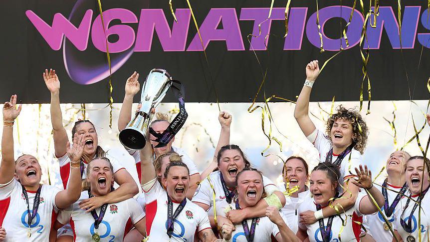 Meg Jones lifts the Women's Six Nations trophy surrounded by team-mates with tickertape falling down