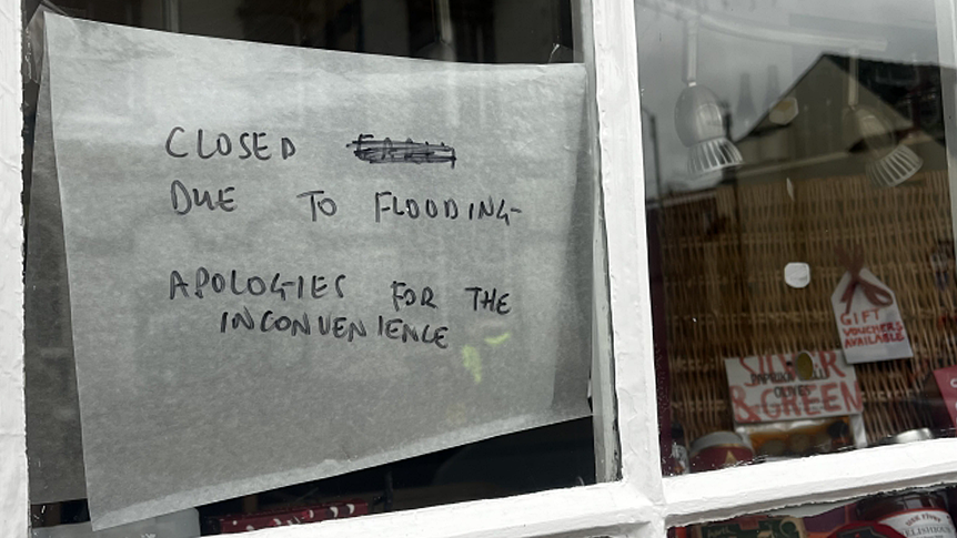 Sign in shop window with hampers in the shop front