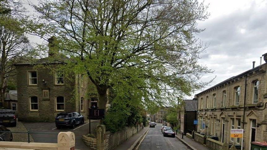 A road lined with light coloured stone buildings