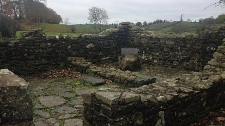 The ruins of an old stone cottage, photographed on a cloudy day