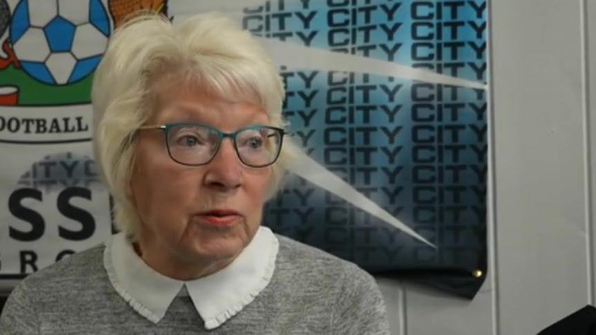 A woman speaking in a social club