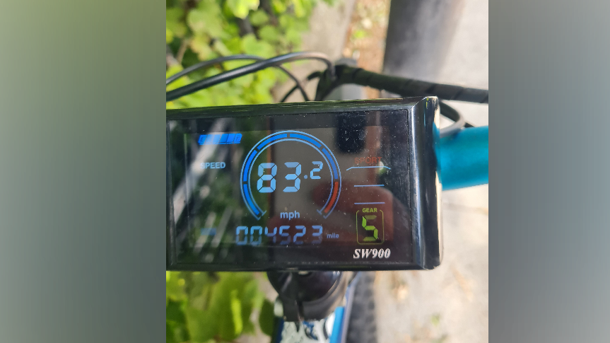 A camera screen sits on a bike. The display shows a circular, digital chart and the number in the middle reads 83.2.