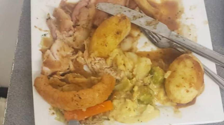 Food left by customer at the Star Inn Vogue in St Day. The partially-eaten square plate looks about three-quarters full, containing some poultry, roasted vegetables and half a Yorkshire pudding. A knife and fork are placed near the remaining food.