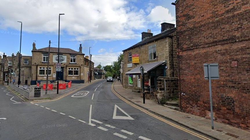 A google street view image of Otley Road, in Headingley, Leeds. The road is lined with brick and stone buildings