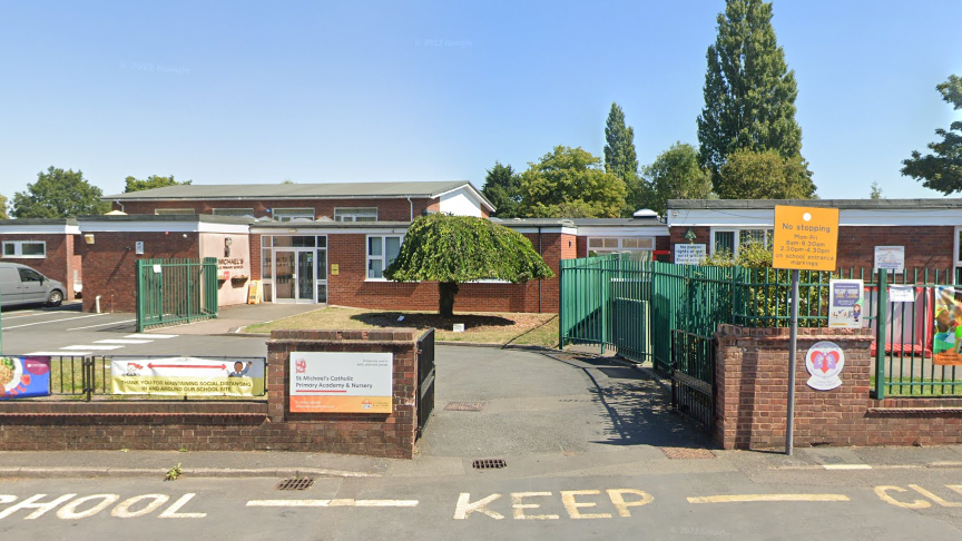 The school looks to be on one level with a brick wall either side of its entrance.