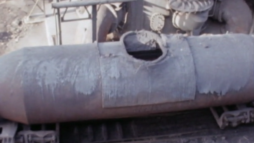A damaged grey torpedo ladle with a hole in the top.