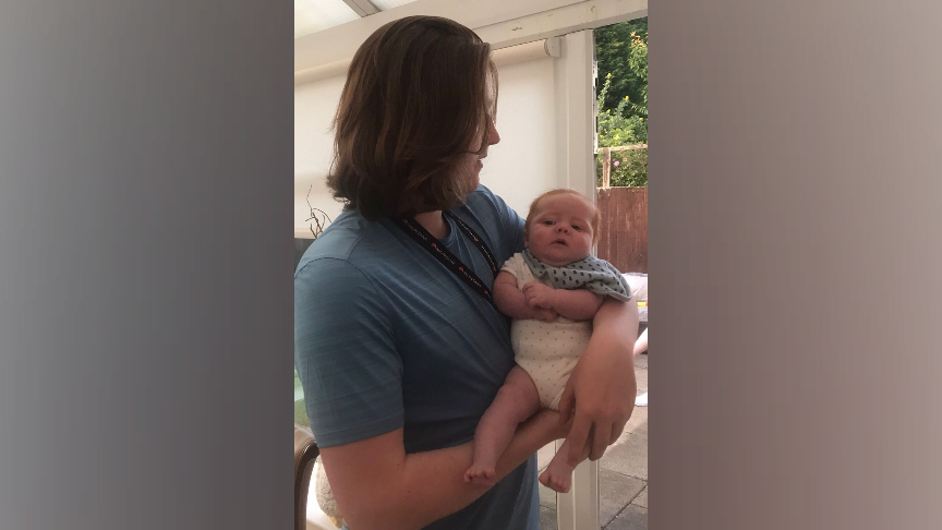 A young teen with long brown hair holds a small baby