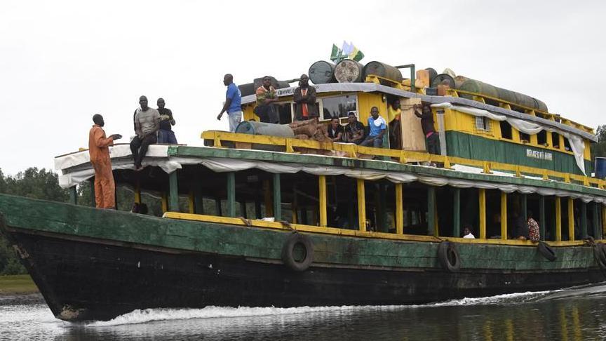 A big passenger boat with some people standing on the deck in Akuku Tori district of Rivers State, Nigeria
