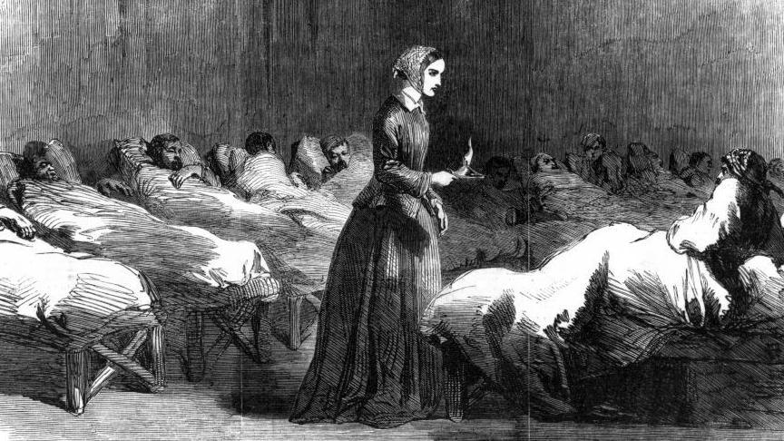 A black and white pencil sketch of Florence Nightingale standing in the middle of a row of beds with patients in them, holding a candle