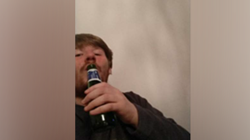 William Edwards in a selfie, holding a bottle of beer up to his lips