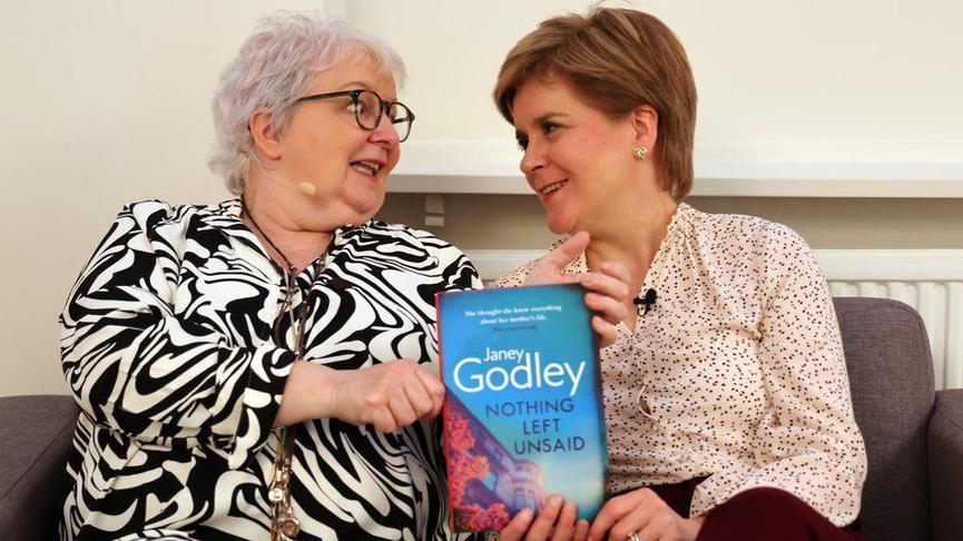 Janey Godley and Nicola Sturgeon, holding a copy of Ms Godley's book. 