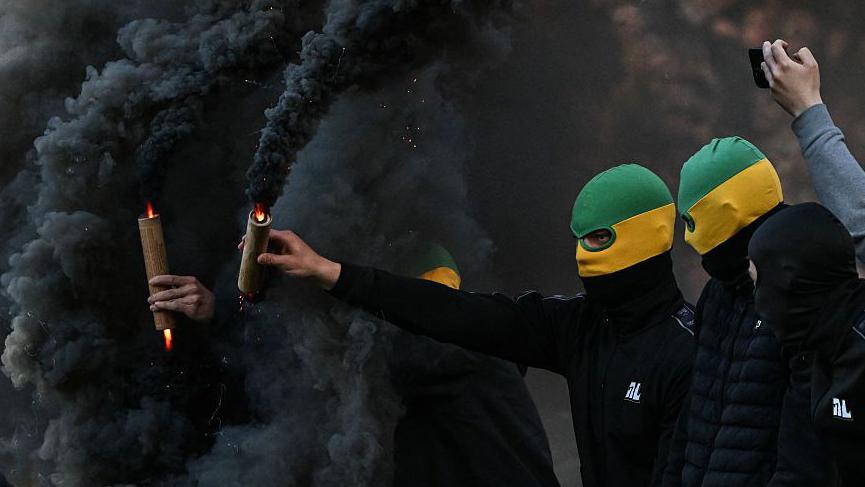 Nantes' supporters holding smoke flares attempt to invade the pitch during the French L1 football match between FC Nantes and Toulouse