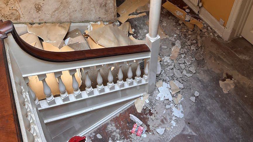 Crumbling plaster at bottom of stairwell