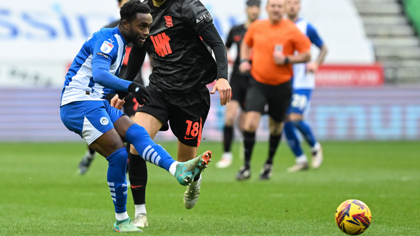 Steven Sessegnon hits the ball with his left foot for Wigan in a League One match against Birmingham City in January 2025