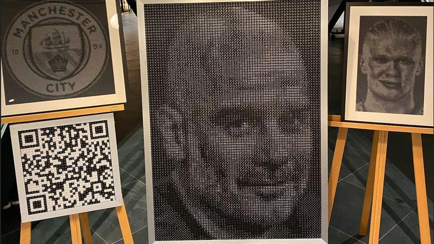 A portrait of Pep Guardiola made from dice alongside a Manchester City club crest, a smaller portrait of Erling Haaland and a QR code.