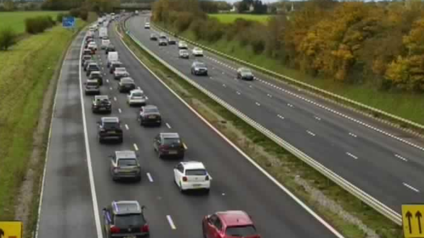 A still from a camera showing long queues of cars along the left two lanes of the M4