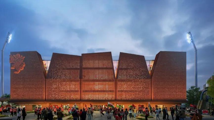 Dyma gynllun rhithiol o'r cynllun ar gyfer y Kop, eisteddle newydd y Stok Cae Ras. Mae'n adeilad mawr gyda 5 panel a'r ddraig goch i'w gweld ar ochr chwith y stadiwm. Mae cefnogwyr yn chwifio baneri y tu allan i'r stadiwm newydd.