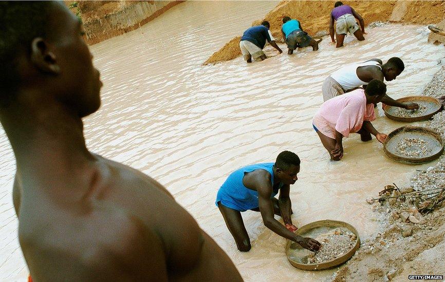 Workers pan for diamonds in a government controlled diamond mine June 15, 2001 near Kenema, Sierra Leone.