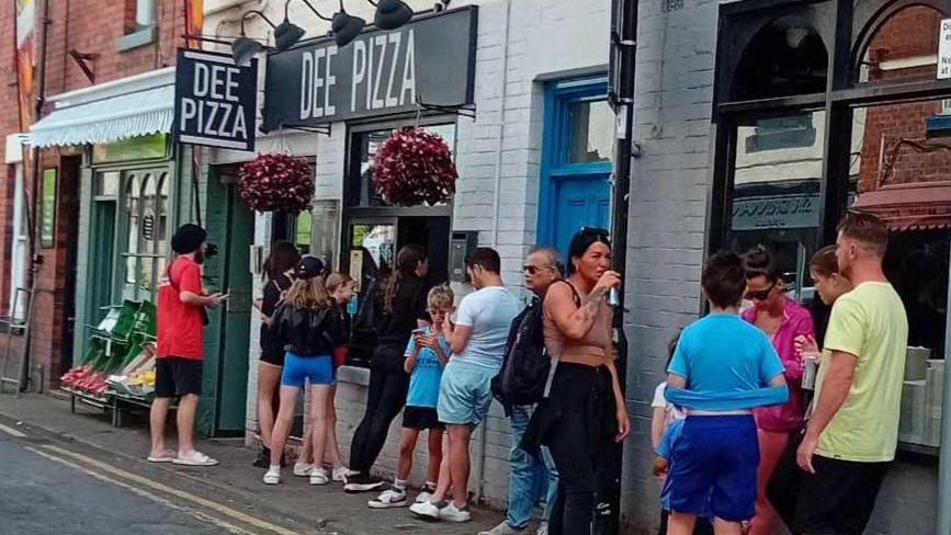 People queue outside Dee Pizza in Llangollen.