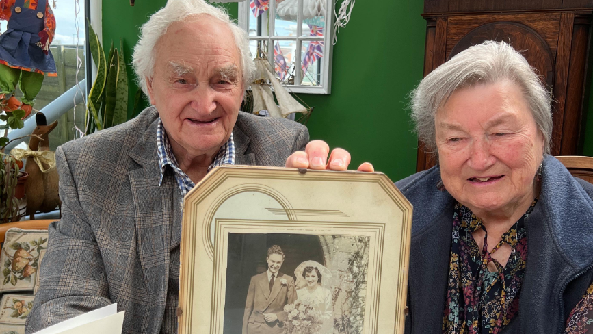 Barry and Betty Jones smile as they pose with their wedding day photograph