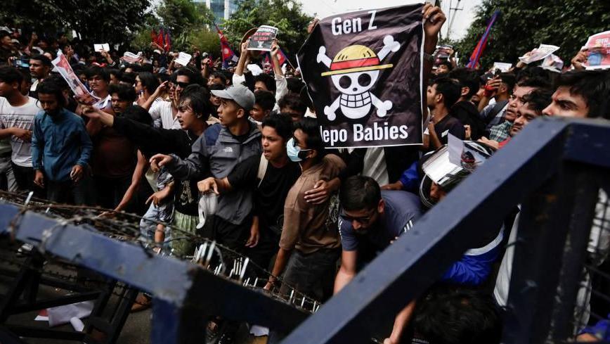 Demonstrators try to break through police barricades in Kathmandu during a protest against corruption and the government's decision to ban several social media platforms