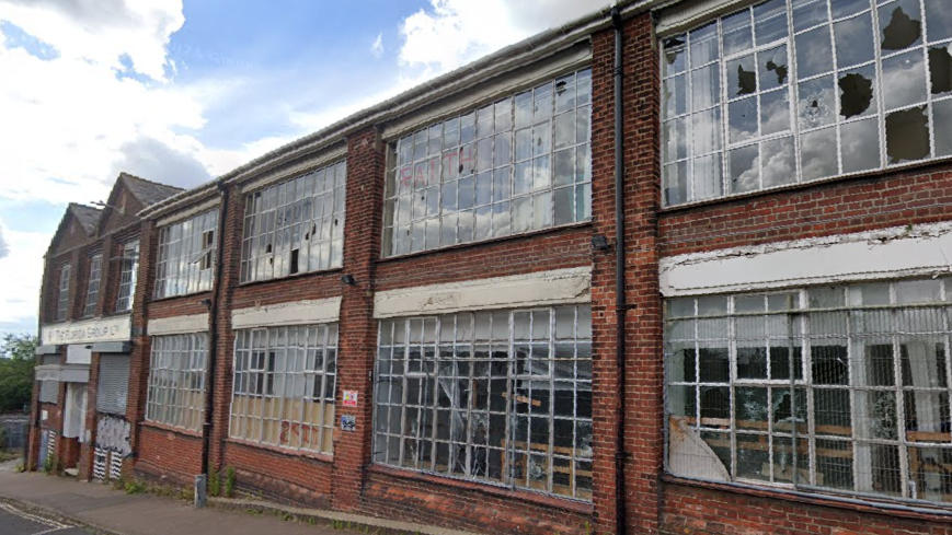 Google Street View picture of a disused two-storey brick factory building. Some of its windows are smashed.