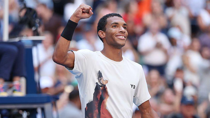 Felix Auger-Aliassimes smiles and holds up his fist to celebrate