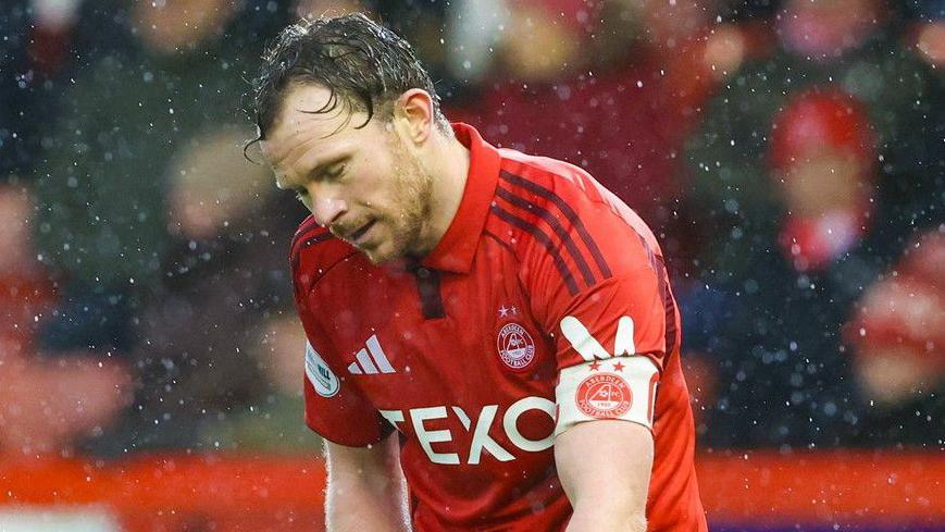 Aberdeen's Nicky Devlin looks dejected at full time during a William Hill Premiership match between Aberdeen and Dundee at Pittodrie Stadium, on February 21, 2026, in Aberdeen, Scotland.