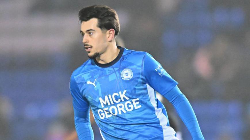 Ryan De Havilland looks for the ball while playing a match for Peterborough United.