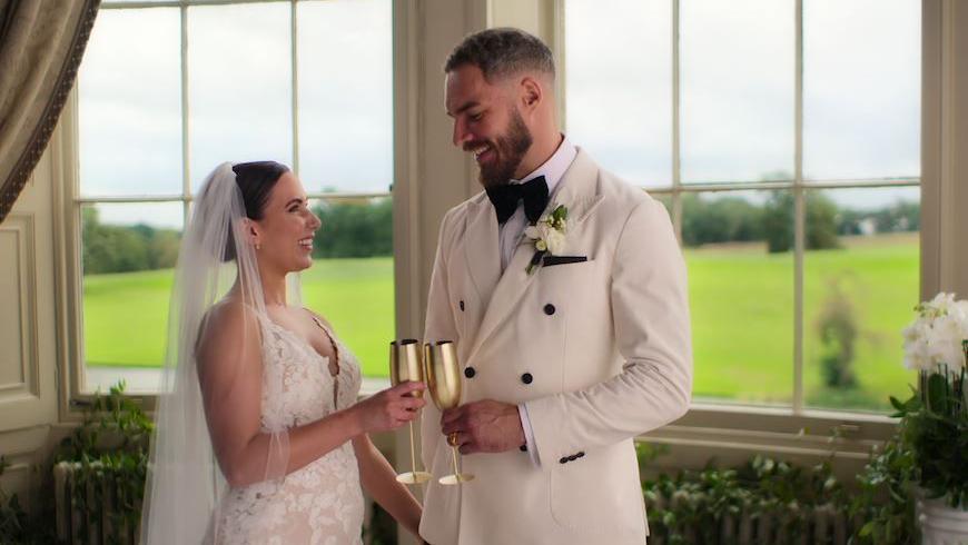 A woman and man in white dress and tux on their wedding day