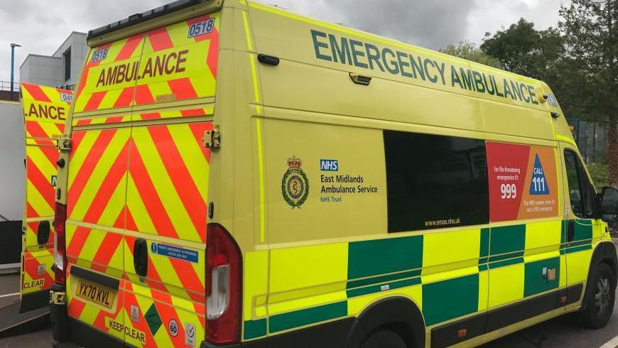 A yellow ambulance parked in a space. 