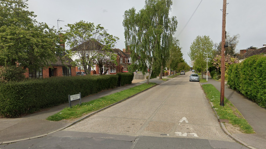 Chelmerton Avenue, showing a road, road sign, green verges either side, hedging around front gardens and detached houses 