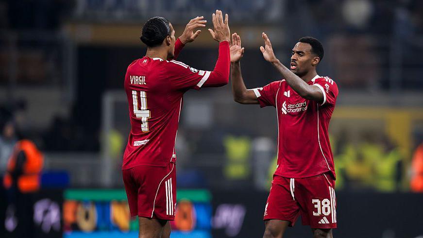 Virgil van Dijk and Ryan Gravenberch high-five each other. 