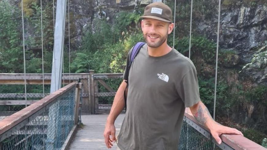 A man in a cap in a grey T-shirt 