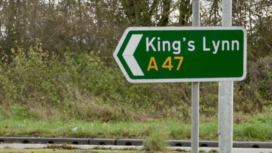 A green road sign which reads "King's Lynn" and "A47"