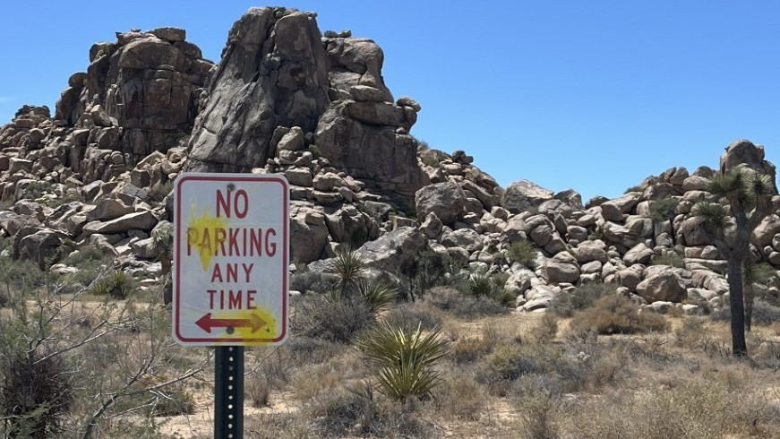 Photo showing road sign at Joshua Tree National Park with yellow paint splatters