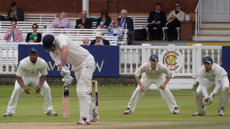 Slip fielders and wicketkeeper watch batsman play a shot