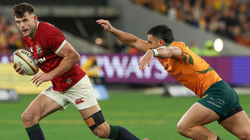 Blair Kinghorn runs past an Australia player