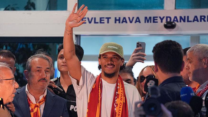 Leroy Sane waves to crowd at an airport in Istanbul