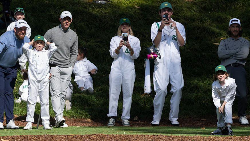 Frankie Fleetwood reacts on the ninth tee at Augusta during the Par 3 Contest - with onlookers including his father Tommy plus Rory McIlroy and Shane Lowry